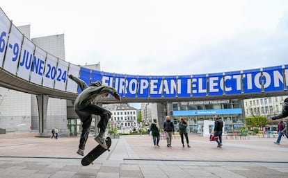 Un patinador salta cerca de los anuncios de las próximas elecciones de la Unión Europea frente al edificio del Parlamento Europeo en Bruselas.