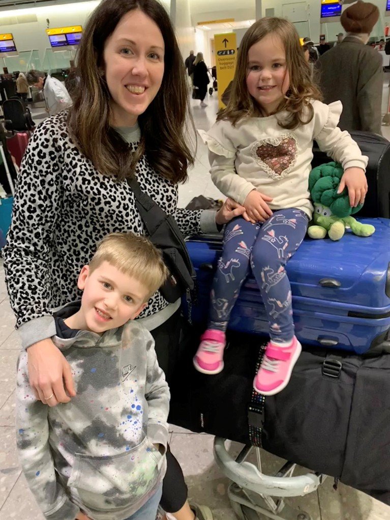 Laura Carter con sus dos hijos antes de embarcar en un aeropuerto.