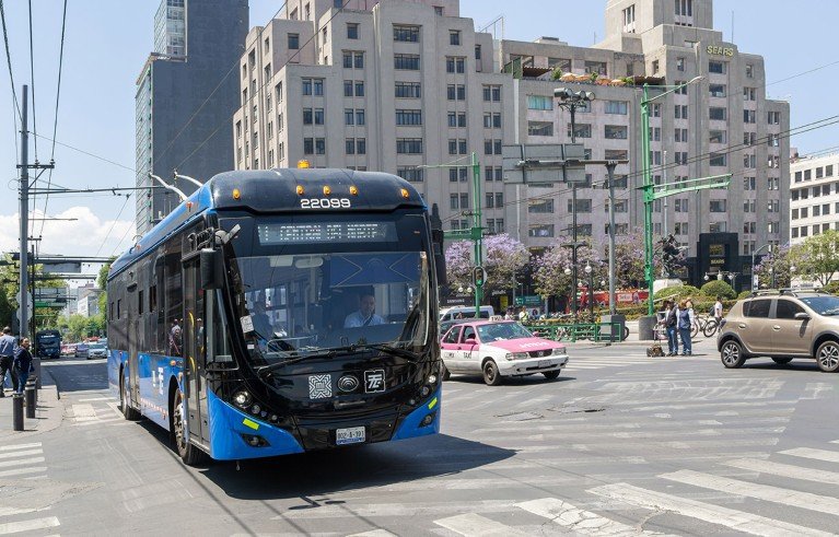 Un autobús eléctrico azul fotografiado en un cruce de carreteras concurrido en la Ciudad de México.