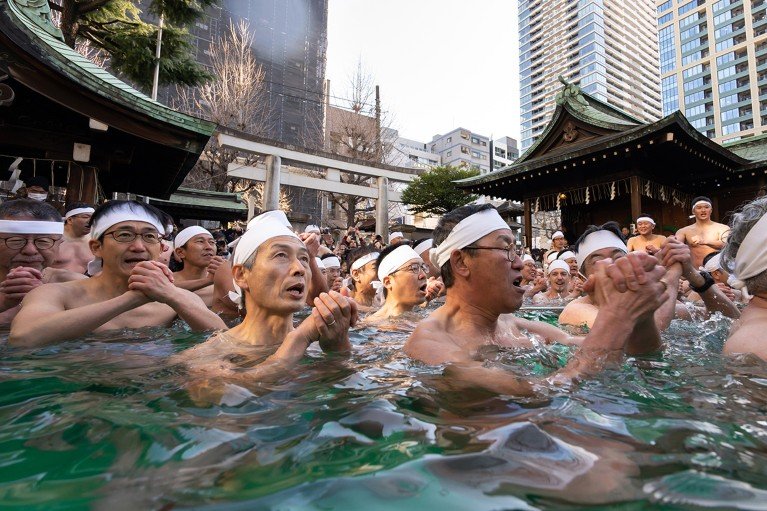 Participantes se bañan en agua helada durante un ritual sintoísta en el Santuario Inari Teppozu en Tokio, Japón.