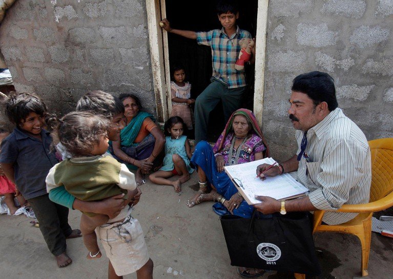 Un trabajador del censo en 2011 toma notas de mujeres y niños en una zona de barrios bajos en Hyderabad, India.