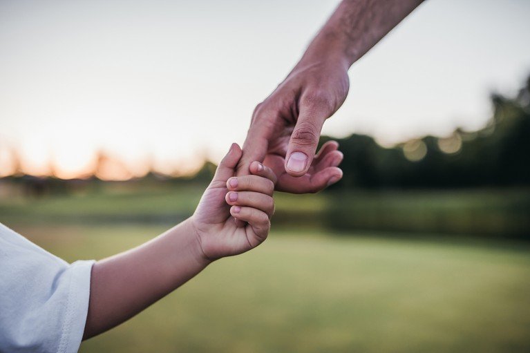Un niño pequeño toma la mano de un adulto
