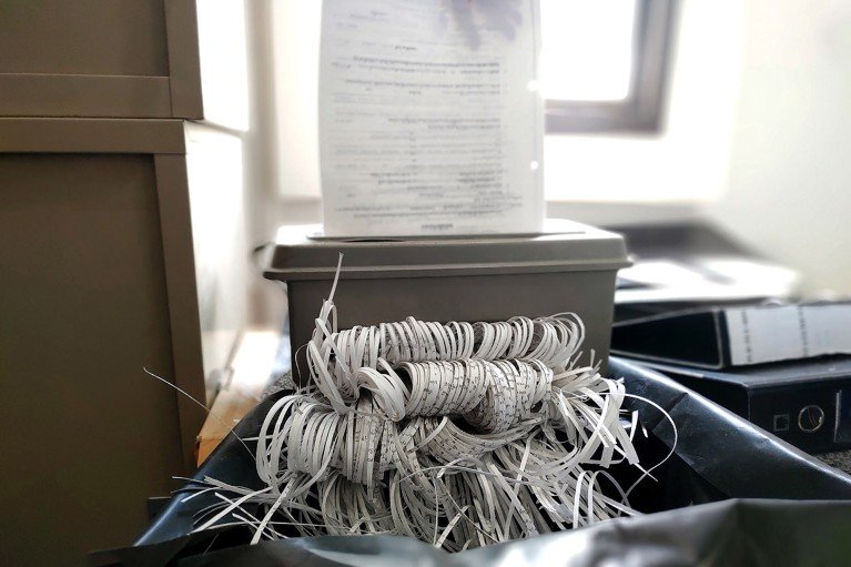 Un montón de papel triturado sale de una trituradora de documentos.