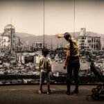 Una madre y dos niños en el Museo de la Paz de Hiroshima observan una gran fotografía del daño causado por la bomba atómica.